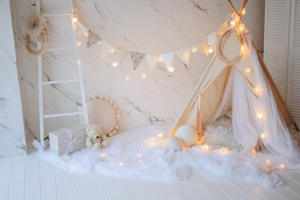 A stylish and cozy child’s room featuring a decorative tent and soft lighting, creating a warm atmosphere.